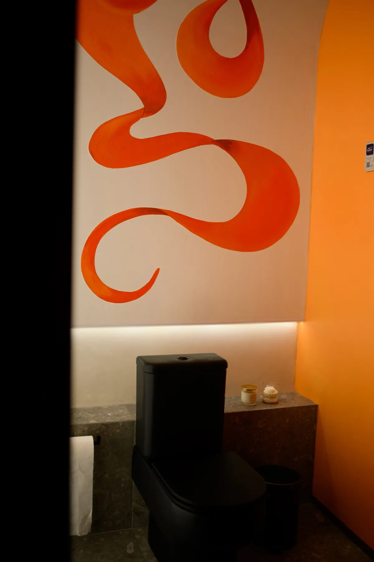 Sanitário executado com mural laranja